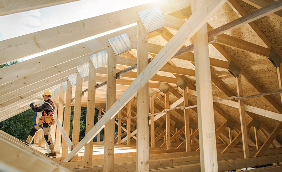 Construction worker with a hard hat working on a wooden structure.