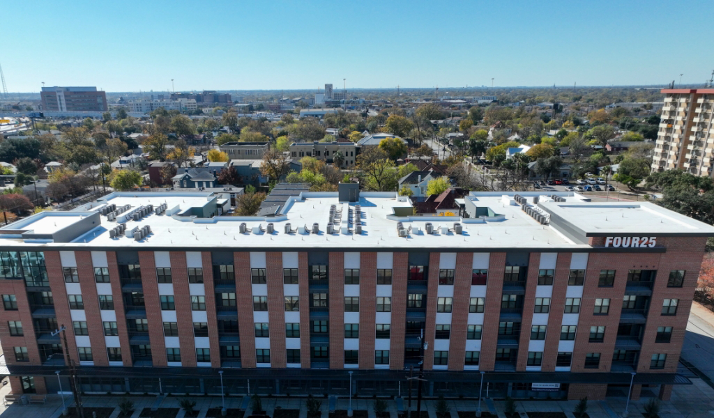 Drone view of Four25 San Pedro housing complex facade, with downtown San Antonio visible in the background.